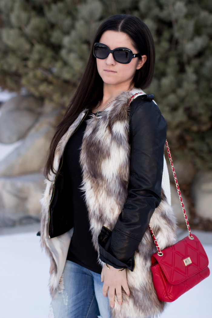 styling a faux fur vest, faux leather jacket, red handbag, ripped jeans, boyfriend jeans, casual outfit idea, winter outfit, calvin klein