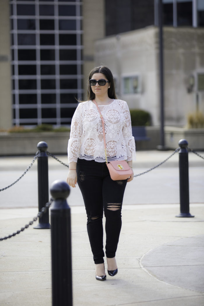styling a white crochet top for Spring, bell sleeve lace top, black ripped skinny jeans, pink Tommy Hilfiger crossbody, nude bra,